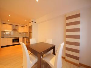 a dining room with a wooden table and white chairs at Apartment with Sea Views in Sanxenxo +31 photos