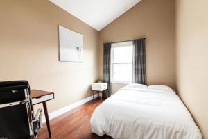 a bedroom with a bed and a desk and a window at Quiet apt only 15 mins from Midtown NYC in Jersey City