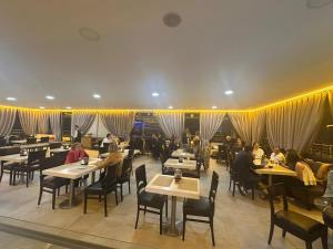 a dining room with people sitting at tables in a restaurant at Park Hotel in Edirne