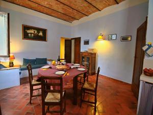 a dining room with a table and chairs and a couch at Attractive apartment in old farmhouse on the estate with pool in Umbertide