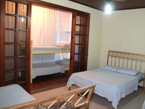um pequeno quarto com 2 camas e uma janela em Pousada Praia da Costa em Vila Velha