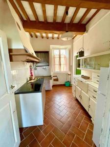 PrataにあるAntica casa nel borgo medievale di Prataのタイルフロアの広いキッチン(白いキャビネット付)