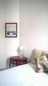 a bedroom with a bed and a table with a lamp at Hostel Rossio Alcobaça in Alcobaça