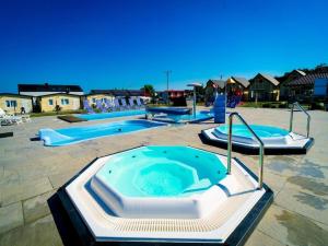 ein großer Pool mit zwei Whirlpools in einem Hof in der Unterkunft Holiday resort with Pool, Whirlpool, Sauna, Ustronie Morskie in Ustronie Morskie