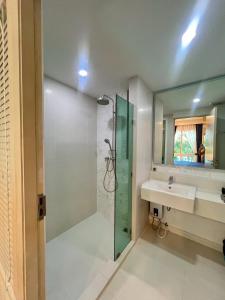 a bathroom with a shower and a sink and a mirror at เซเว่น ซี คอนโดรีสอร์ท สวนน้ำ in Jomtien Beach