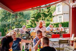 a group of people sitting at an outdoor restaurant at Holiday homes in the Schierke Harzresort on the Brocken, Schierke in Schierke +30 photos