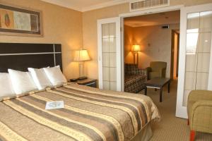 ein Hotelzimmer mit einem Bett und einem Wohnzimmer in der Unterkunft The George Dawson Inn & Conference Centre in Dawson Creek