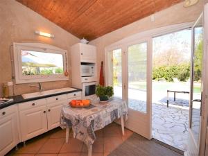 a kitchen with a table and a sink and a window at Cosy house with private pool near Valence in Alixan