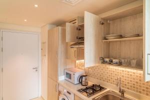 迪拜Seven Palm Jumeirah Studio - Private Beach Access的厨房里有水槽和微波炉