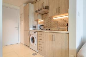 迪拜Seven Palm Jumeirah Studio - Private Beach Access的厨房里有洗衣机和微波炉