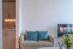 迪拜Seven Palm Jumeirah Studio - Private Beach Access的客厅配有带2个蓝色枕头的沙发