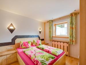 a bedroom with a bed with pink and green sheets at Wohnung in Silbertal nahe Skilift in Silbertal