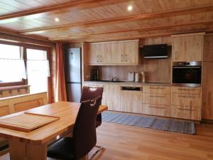 a kitchen with a wooden table and a wooden floor at Wohnung in Silbertal nahe Skilift in Silbertal