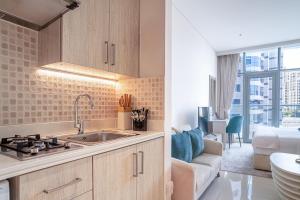 迪拜Seven Palm Jumeirah Studio - Private Beach Access的带水槽的厨房和客厅