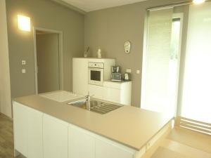 a kitchen with a sink and a microwave at Family Escape with Garden in Abreschviller