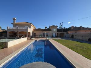 a villa with a swimming pool in front of a house at Villa in El Agar with Private Pool and Beaches in Mina Blanca
