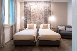 a hotel room with two beds and a couch at Vittorio Veneto 25 in Modena