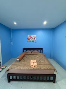 a bedroom with a large bed with a blue wall at ปาล์มเฮ้าส์ PalmHouse in Chanthaburi +9 photos