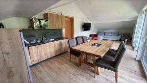 a kitchen and dining room with a wooden table and chairs at Apartments Garden House in Niedernsill