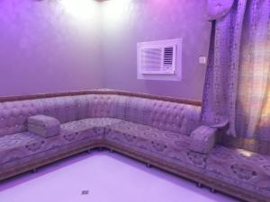 a purple room with a couch and a window at شقة مفروشه بالمجاردة 2 in Al Majaridah
