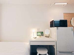 a room with a desk with a refrigerator and a chair at W hostel in Seoul