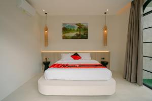 a bedroom with a white bed with a red pillow at SOOJIWA VILLA by Taman Bali in Dalung +23 photos