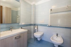 Un baño con lavabo, inodoro y espejo. en San Frediano Lidia's home, en Florencia