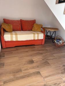 an orange couch in a room with a wooden floor at Sky Peak in Stare Bystre +1 photo