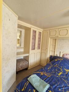 a bedroom with a bed with a blue comforter at Przyczepa holenderska ROCO in Rewa