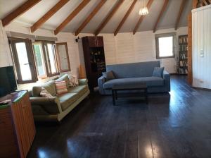 a living room with two couches and a tv at yurt experience in Istiaía