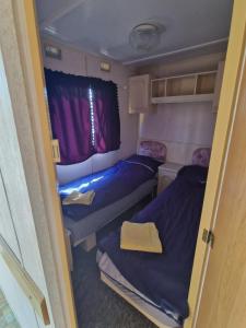 a small room with two beds and a window at Przyczepa holenderska ROCO in Rewa +4 photos