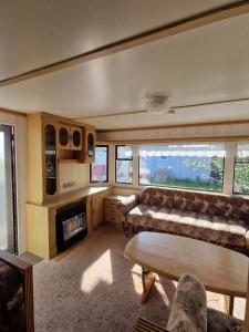 a living room with a couch and a fireplace at Przyczepa holenderska ROCO in Rewa