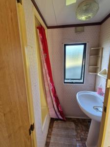 a small bathroom with a sink and a window at Przyczepa holenderska ROCO in Rewa