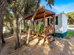 a tiny house in the woods with a porch at Mobile homes Rosemary in camping Strasko, Novalja in Novalja