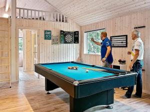 two men standing in a room with a pool table at Luxury Pool Villa in Dronningmolle - By Traum Ferienwohnungen in Gilleleje
