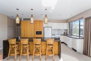 a kitchen with a wooden table and chairs at Dolphin Views in Burrill Lake +17 photos