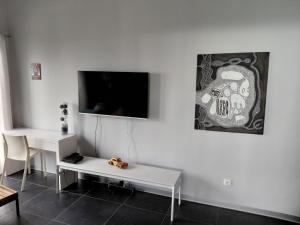 a white room with a table and a tv on the wall at Latitude vue unique in Les Trois-Îlets
