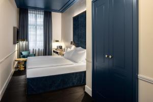 a bedroom with a white bed and a blue door at AMO by AMANO Friedrichstrasse in Berlin