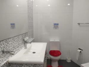 een badkamer met een wastafel en een toilet met een rode stoel bij Hotel Good Life Unawatuna in Unawatuna