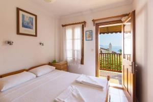 a white bedroom with a bed and a balcony at The White House Kalkan in Kalkan