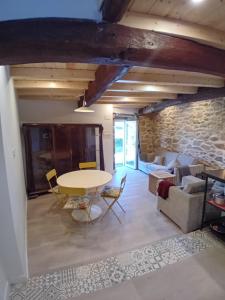 a living room with a table and a stone wall at Duplex en Ribeira Sacra in Sistín +10 photos