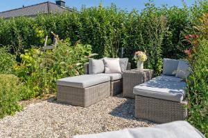 een tuin met twee rieten stoelen en een bankje bij Achtern Hoff in Gnissau