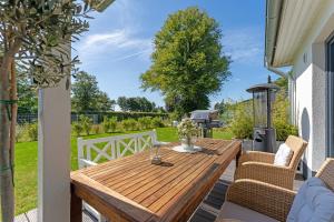 een houten tafel en stoelen op de patio van een huis bij Achtern Hoff in Gnissau +25 foto's