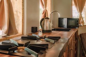 a kitchen with a stove with a microwave and a tv at The Jungle Pearl Resort in Mto wa Mbu