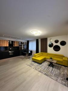 a living room with a yellow couch and a table at Urban Residence in Poiana Brasov