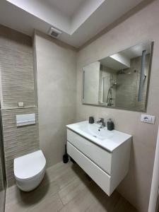 a bathroom with a sink and a toilet and a mirror at Urban Residence in Poiana Brasov