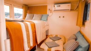 a small room with two beds and two seats at Phinisi Giona Liveonboard in Labuan Bajo