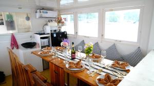 a kitchen with a long wooden table with flowers on it at Phinisi Giona Liveonboard in Labuan Bajo