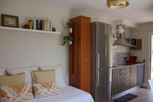 a bedroom with a bed and a kitchen with a refrigerator at Refugio verde con encanto in Vallirana