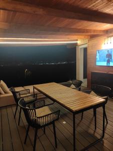 Un comedor con mesa y sillas y un televisor. en Panorama retreat, en Oradea